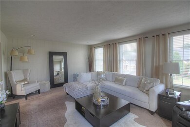 The living room is spacious and neutral. The back 