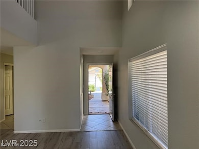 Entryway with a high ceiling, light wood-style flo