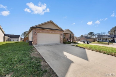 View of front of house with a front lawn, driveway, brick siding, an attached garage, and a residential view
