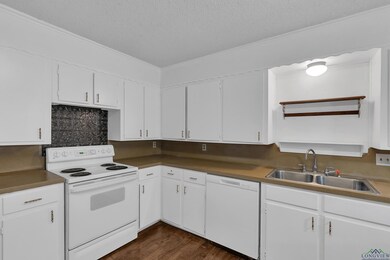 Kitchen featuring sink, white cabinetry, white app