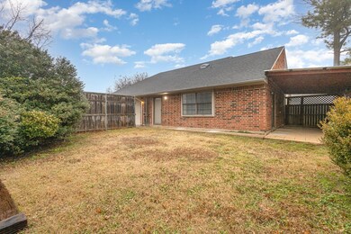 Back of property with a yard and a carport