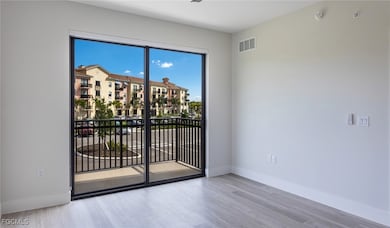 Unfurnished room featuring visible vents, baseboards, and wood finished floors