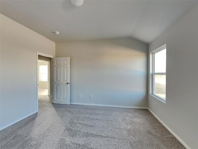 Carpeted spare room featuring vaulted ceiling, bas