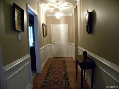 Foyer with hardwood floor, crown molding, chair ra