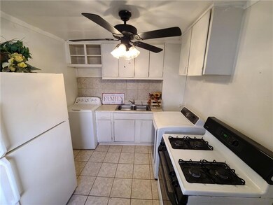 Kitchen with white appliances, a sink, light countertops, and decorative backsplash