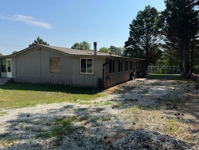 View of property exterior featuring entry steps and a yard