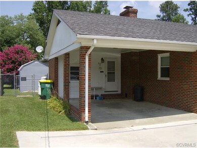 Single car carport with Attached storage, entry into Utility room, & double width/concrete paved driveway