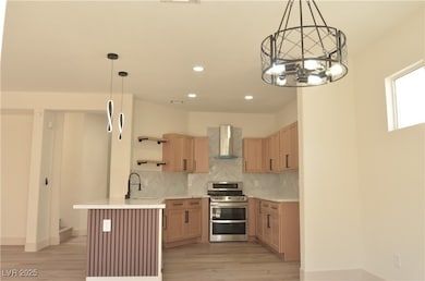 Kitchen featuring range with two ovens, wall chimn