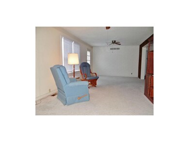 The spacious living room offers 2 ceiling fans, ca