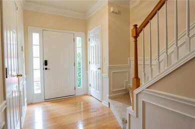 Entryway with stairs, light wood-style floors, orn
