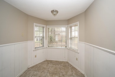 Unfurnished dining area featuring wainscoting and light tile patterned floors