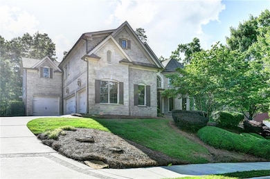 French country style house with a garage, a front yard, driveway, stone siding, and brick siding