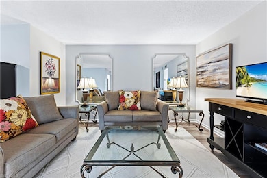 Living area with wood finished floors and a textured ceiling
