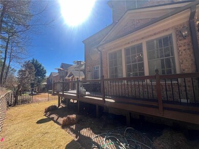 Back of house with brick siding, a deck, and fence