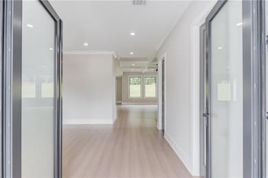 Hall featuring recessed lighting, ornamental molding, and light wood-style flooring