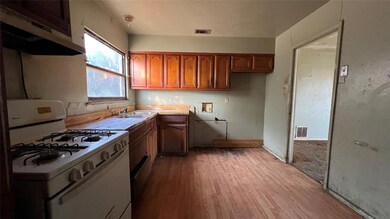 Kitchen with range hood, white gas range oven, lig