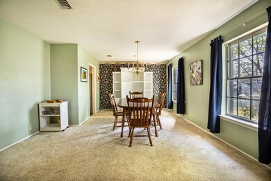 Carpeted dining space featuring a chandelier, visi