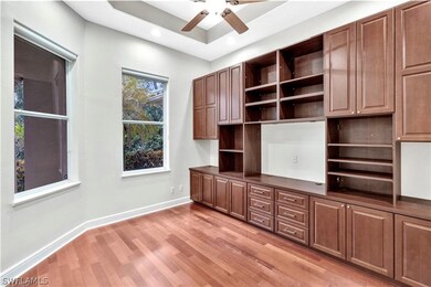 Unfurnished office featuring a tray ceiling, light