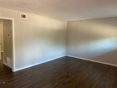 Empty room with visible vents, baseboards, and dar