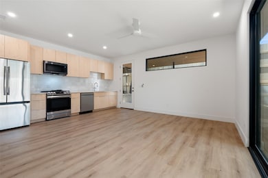 Kitchen with stainless steel appliances, light br
