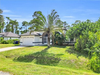 View of front facade featuring an attached garage, concrete driveway, a front lawn, and stucco siding