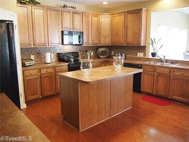 Kitchen. This is a large, open kitchen with pass through to the sunroom for loads of natural light.  Note the island with pull out storage.  Custom backplash.  Owner is leaving all appliances, except refrigerator.  Walk in pantry.