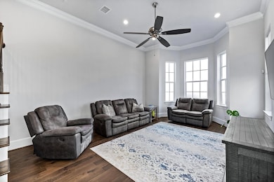 Living room featuring crown molding, dark wood-style flooring, recessed lighting, and a ceiling fan