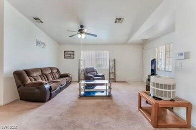 Living area featuring a ceiling fan and carpet flo