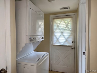 Washroom featuring stacked washer / dryer