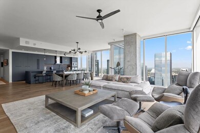 Living room featuring a wall of windows, a skylin
