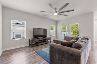 Living room with baseboards, ceiling fan, and wood