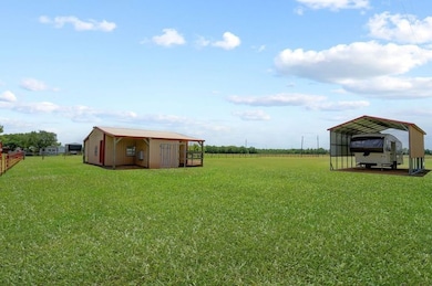 A spacious, open yard with a livestock building an