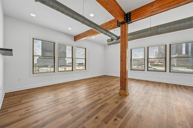 Unfurnished living room with beamed ceiling and ha