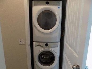 Laundry area with estacked washer and dryer and a