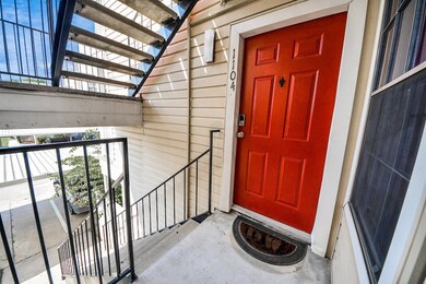 Cozy condo entrance featuring a bold red door with