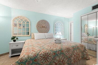 Tiled bedroom featuring a textured ceiling and a c