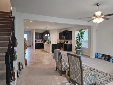 Carpeted dining area featuring ceiling fan