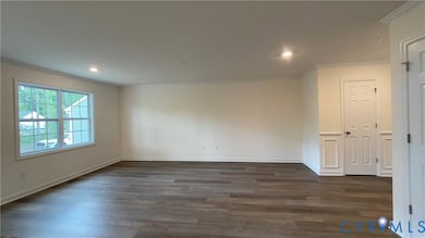 Spare room with ornamental molding, dark wood-style flooring, and recessed lighting