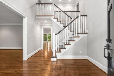 Entrance foyer featuring wood stairway, and a high ceiling
