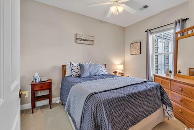Carpeted bedroom featuring ceiling fan