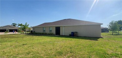 Back of property with stucco siding and a yard