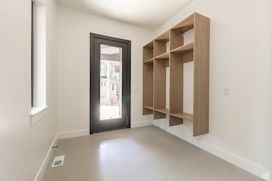 Mudroom featuring concrete flooring and baseboards