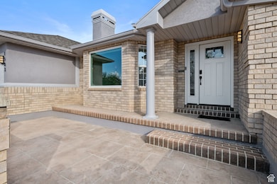Doorway to property with brick siding and a chimney
