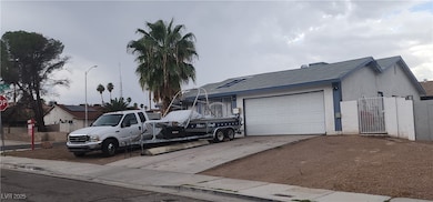 View of front facade with concrete driveway, an attached garage, a shingled roof, and a gate