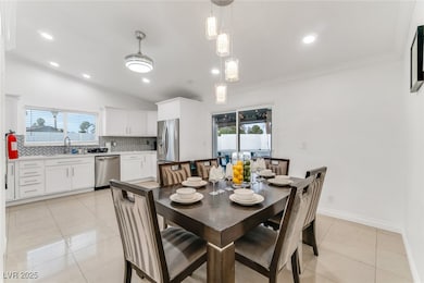 Dining space with light tile patterned flooring, recessed lighting, lofted ceiling, and ornamental molding