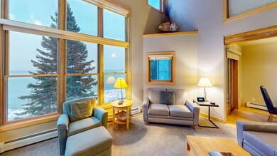 Living room with a baseboard radiator, light carpe