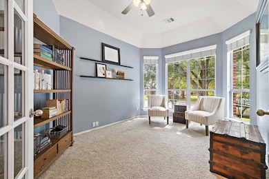 Living area featuring carpet floors, ceiling fan,