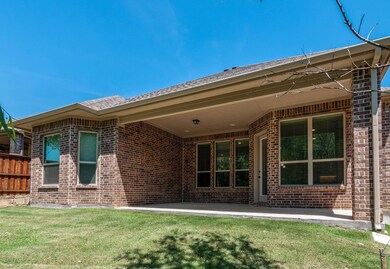 Rear view of property featuring a yard and a patio area