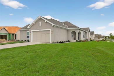 View of front of home featuring stucco siding, concrete driveway, a front lawn, and an attached garage