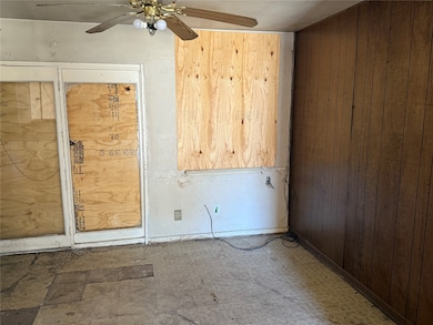 Spare room featuring wooden walls and a ceiling fan